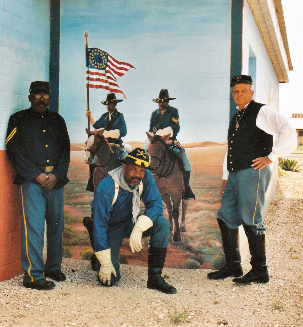 New Mexico Buffalo Soldiers pose in front of a Jal mural.